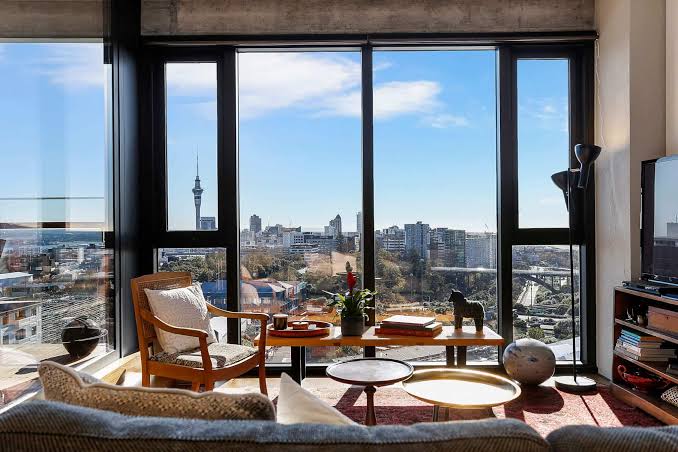 A modern high-rise apartment living room with floor-to-ceiling windows offering a panoramic city skyline view, highlighting premium Apartment Property Management.