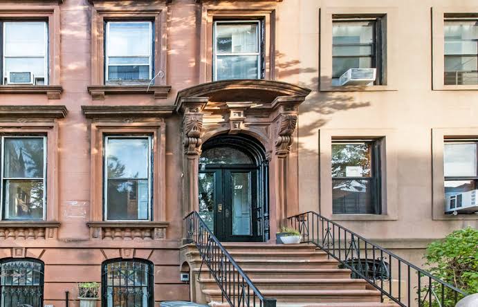 Exterior view of a classic brownstone residential building managed by the Best Property Management Companies.