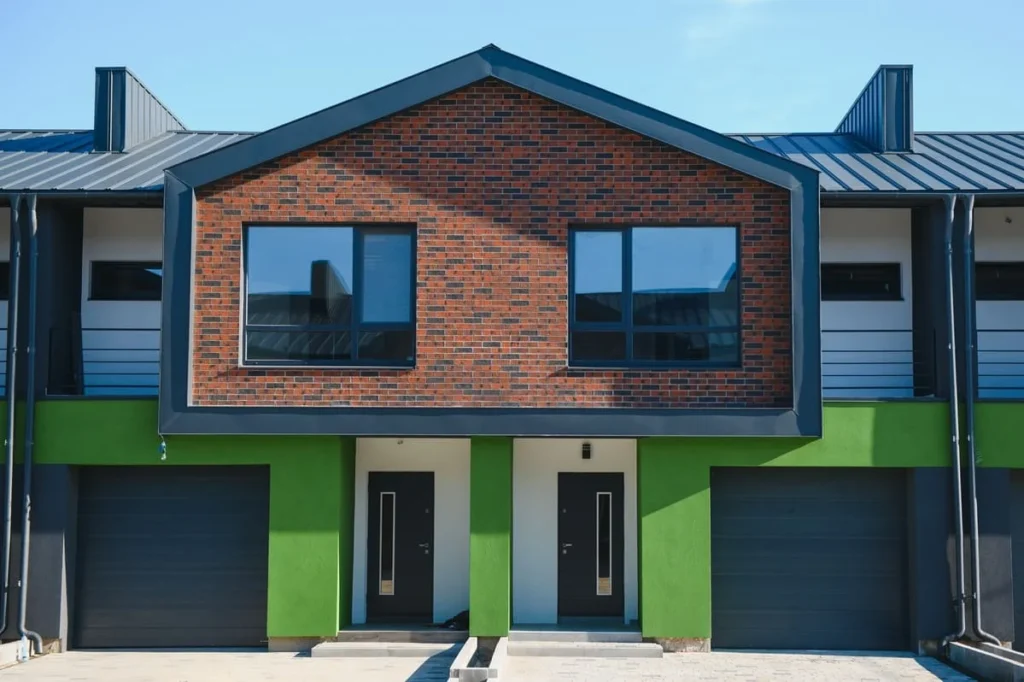 A modern multi-family townhouse exterior with brick accents and garages, representing professional Multi Family Management Brooklyn solutions.