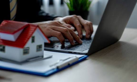 Property Management Solutions specialist using a laptop to manage rental properties, tenant records, and real estate operations efficiently.