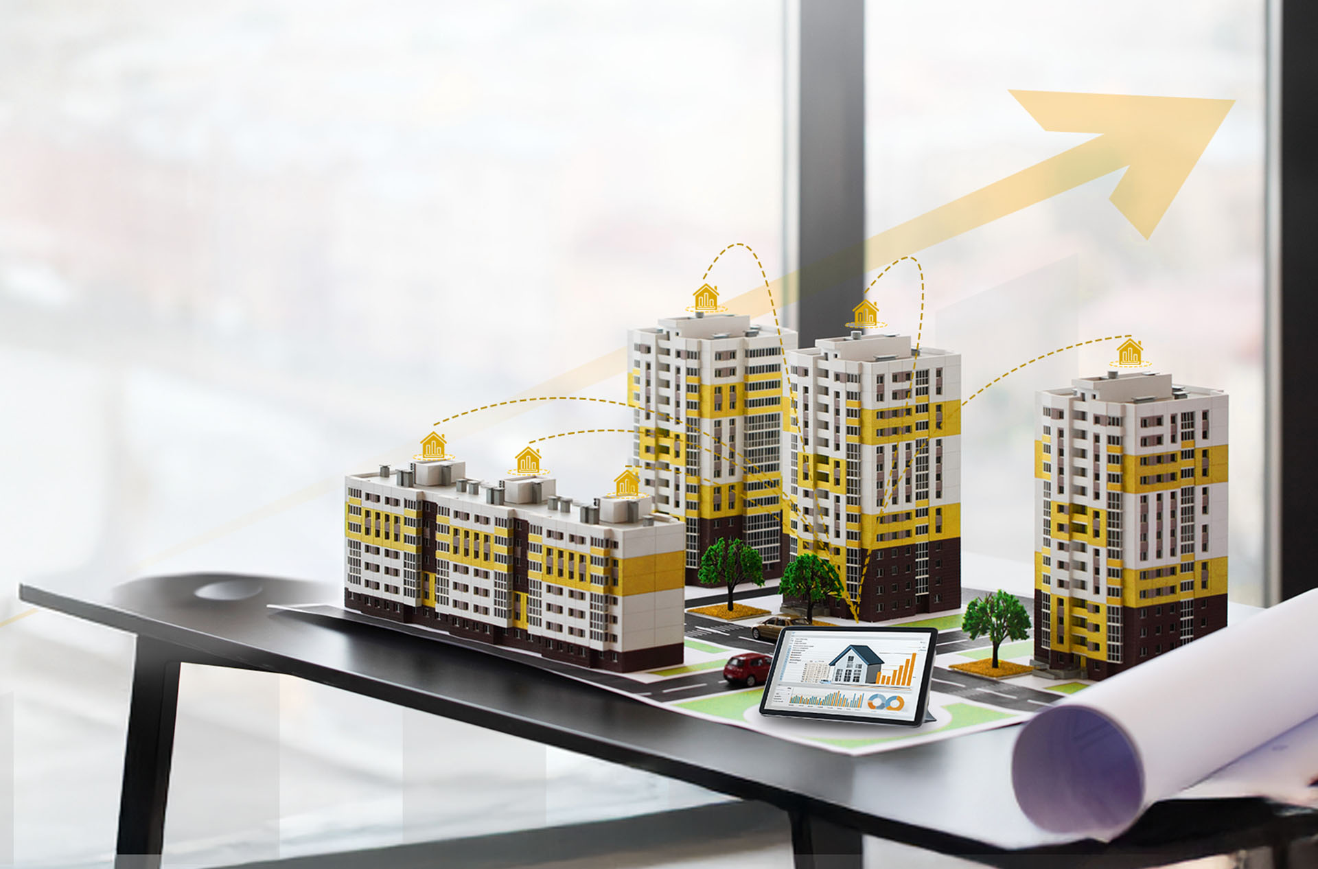 Scale models of apartment complexes displayed alongside a digital dashboard tablet and growth graphics, illustrating modern Residential Building Management solutions.