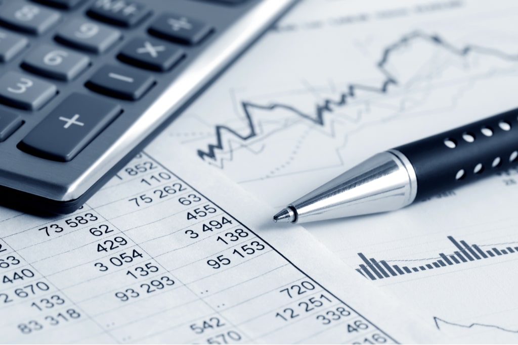 A close-up view of a calculator, pen, and financial spreadsheets highlighting figures and charts, essential tools for managing accurate Rental Property Accounting.
